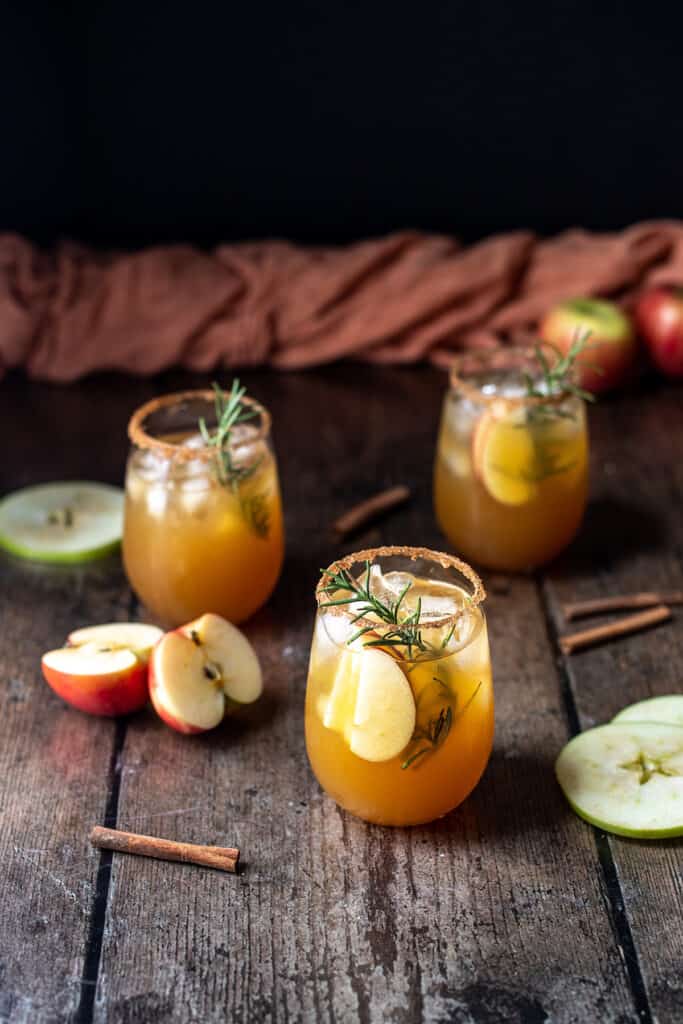 three apple cider margaritas, an orange linen in the background