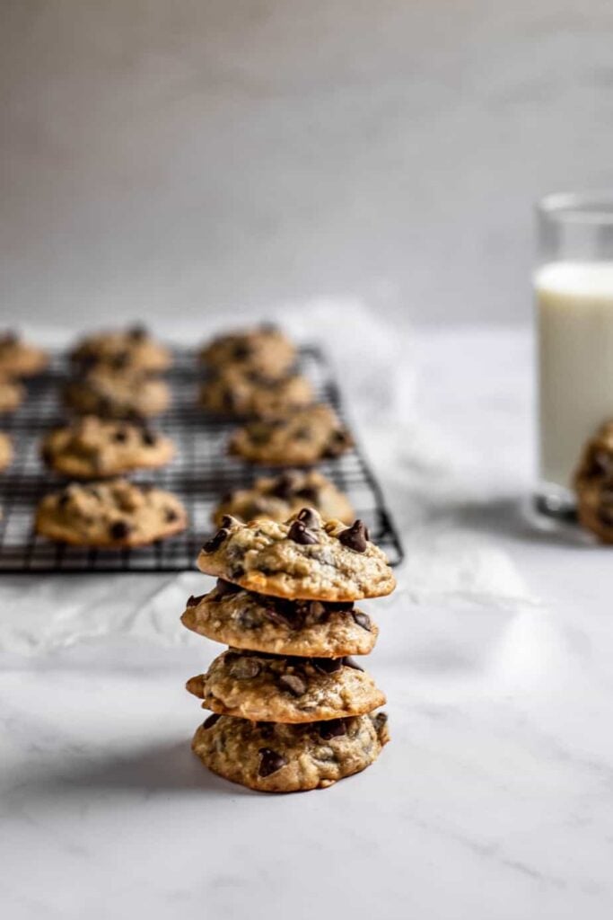 a stack of chocolate chip banana bread cookies, with more cookies on a cooling rack in the background