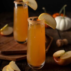 two stemless champagne flutes of apple cider mimosas