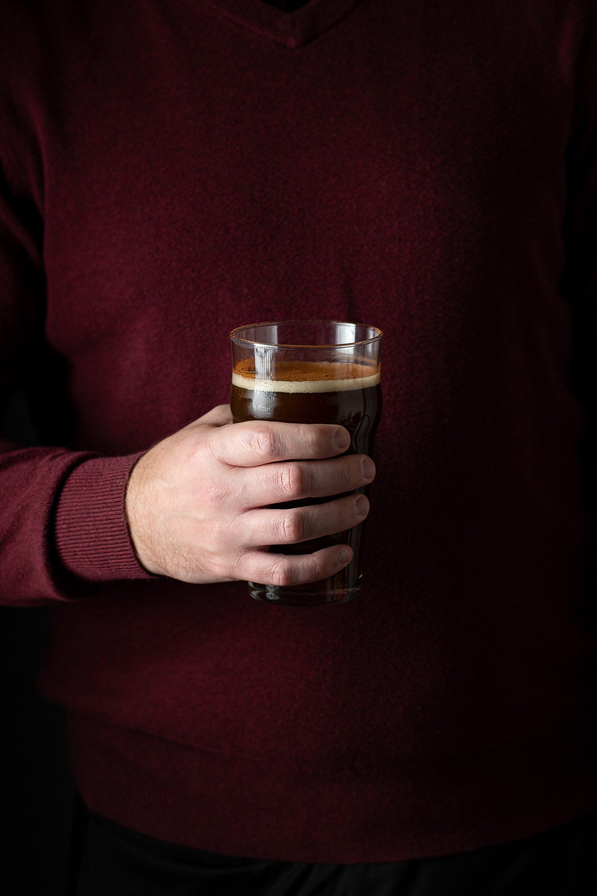a male hand holding a loaded christmas ale
