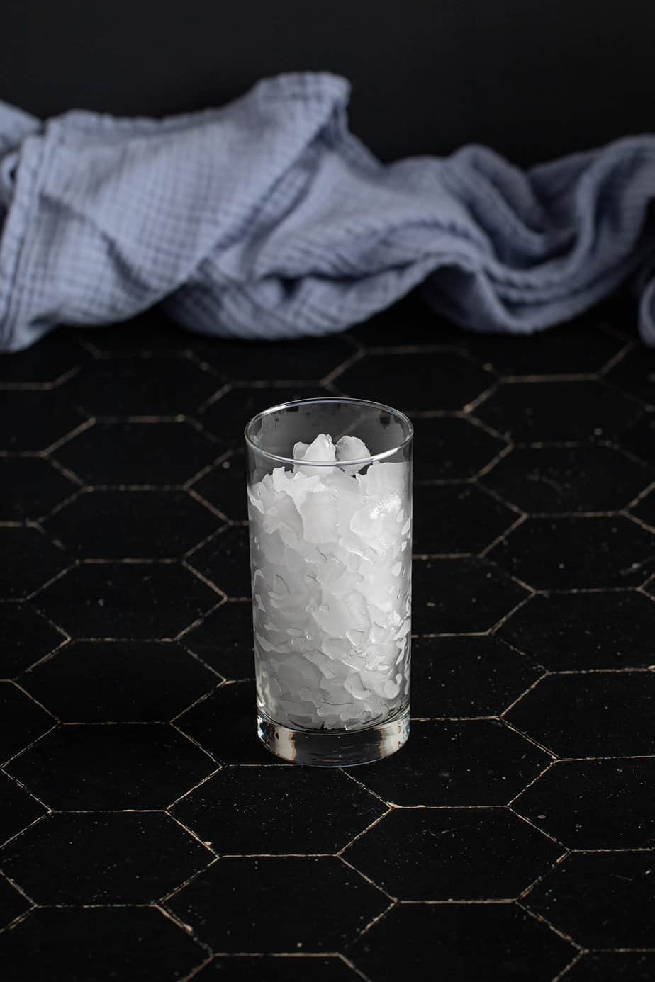 a tall glass filled with crushed ice