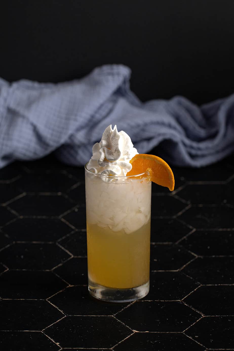 an orange creamsicle crush garnished with whipped cream and an orange wedge