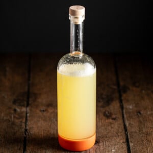 a large bottle full of homemade sour mix.