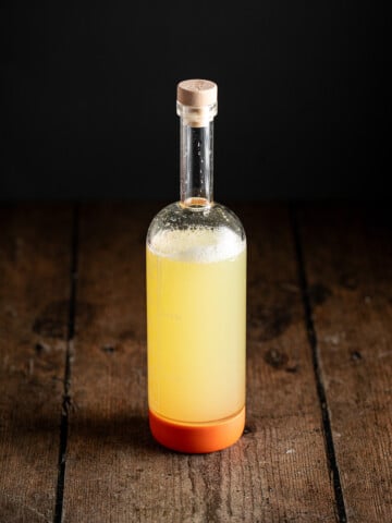 a large bottle full of homemade sour mix.