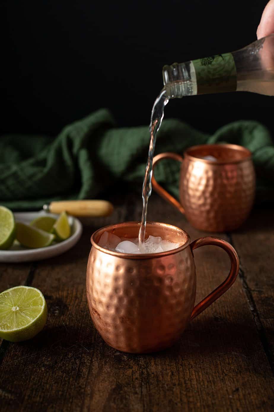 ginger beer being poured into a copper mug