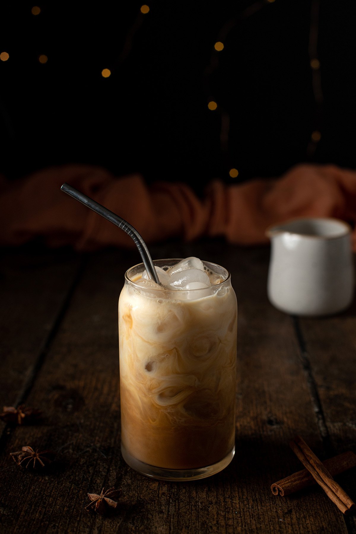 head on view of an iced chai latte with a metal straw