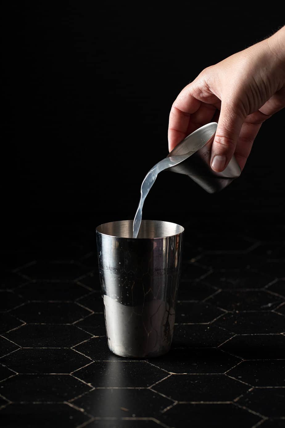 lemonade being poured into a cocktail shaker