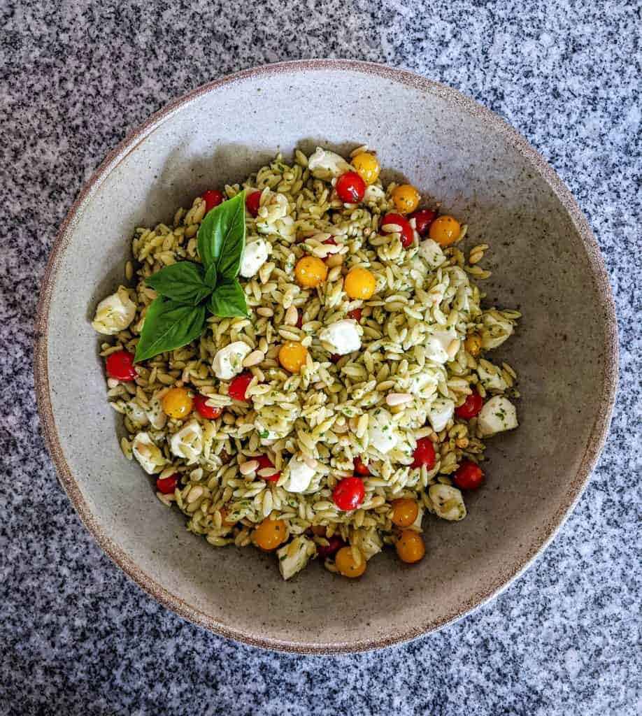 caprese orzo pasta salad in a serving bowl on a granite countertop