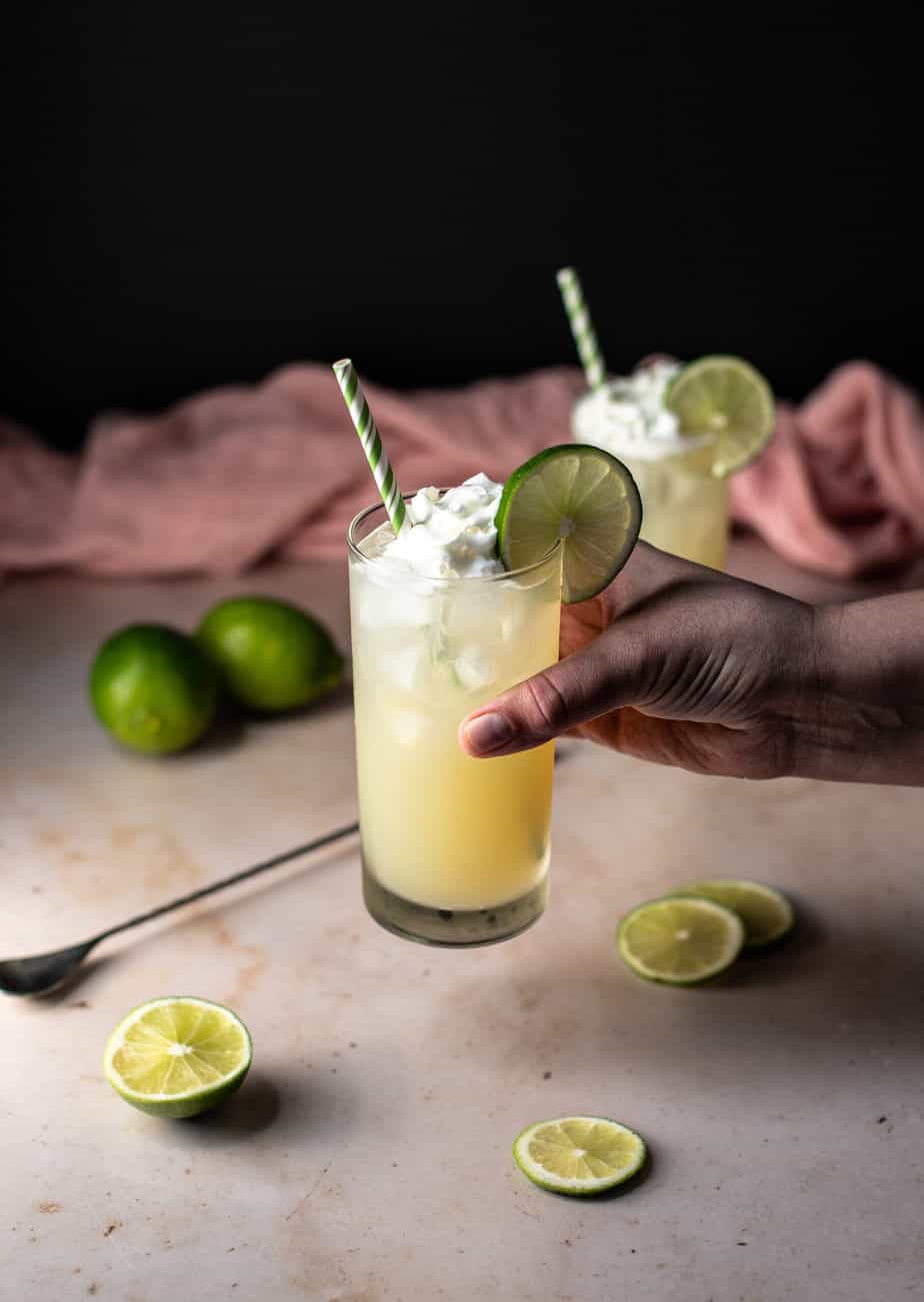 a hand holding a key lime pie crush cocktail