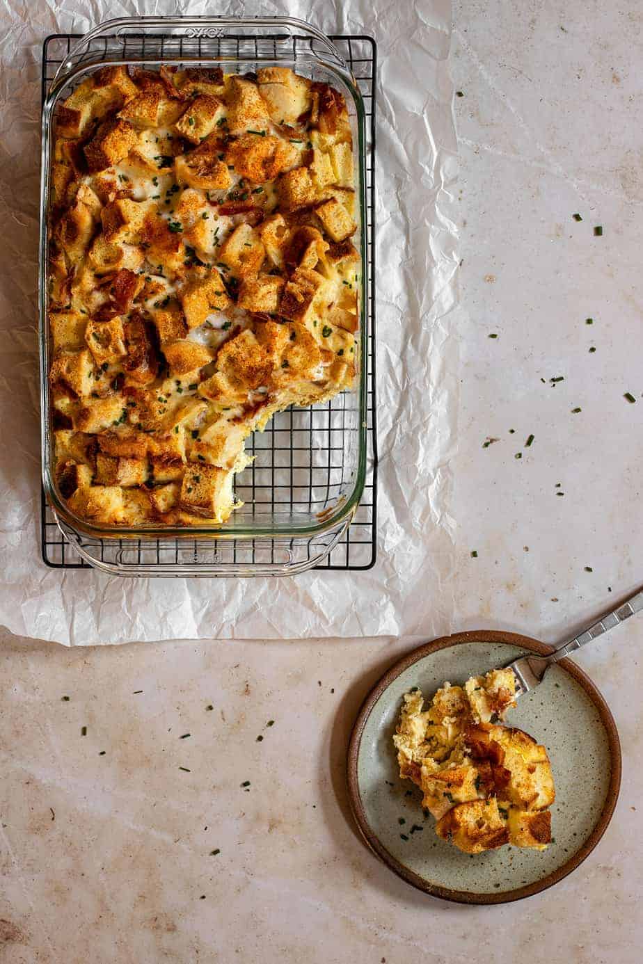 a 9x13-inch pan full of english muffin breakfast casserole with a scoop taken out of it