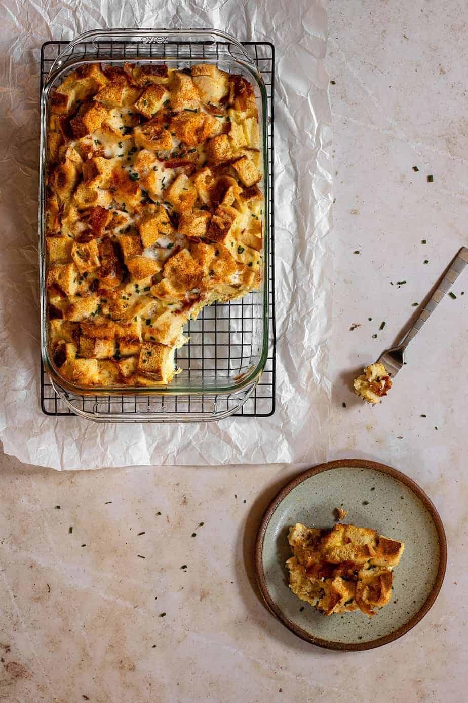 a 9x13-inch pan full of english muffin breakfast casserole with a scoop taken out of it