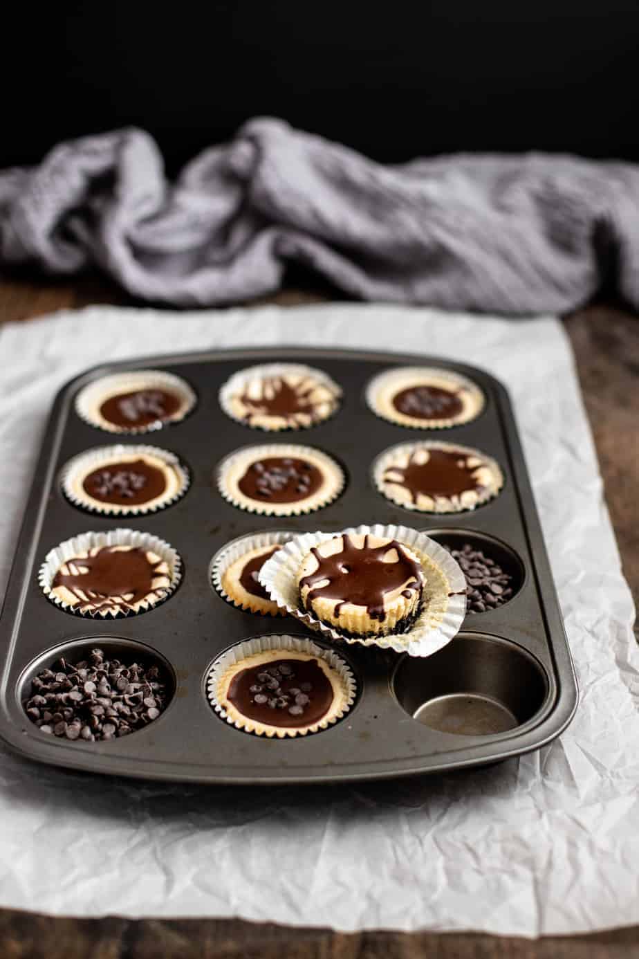 a muffin tin is full of mini cheesecakes