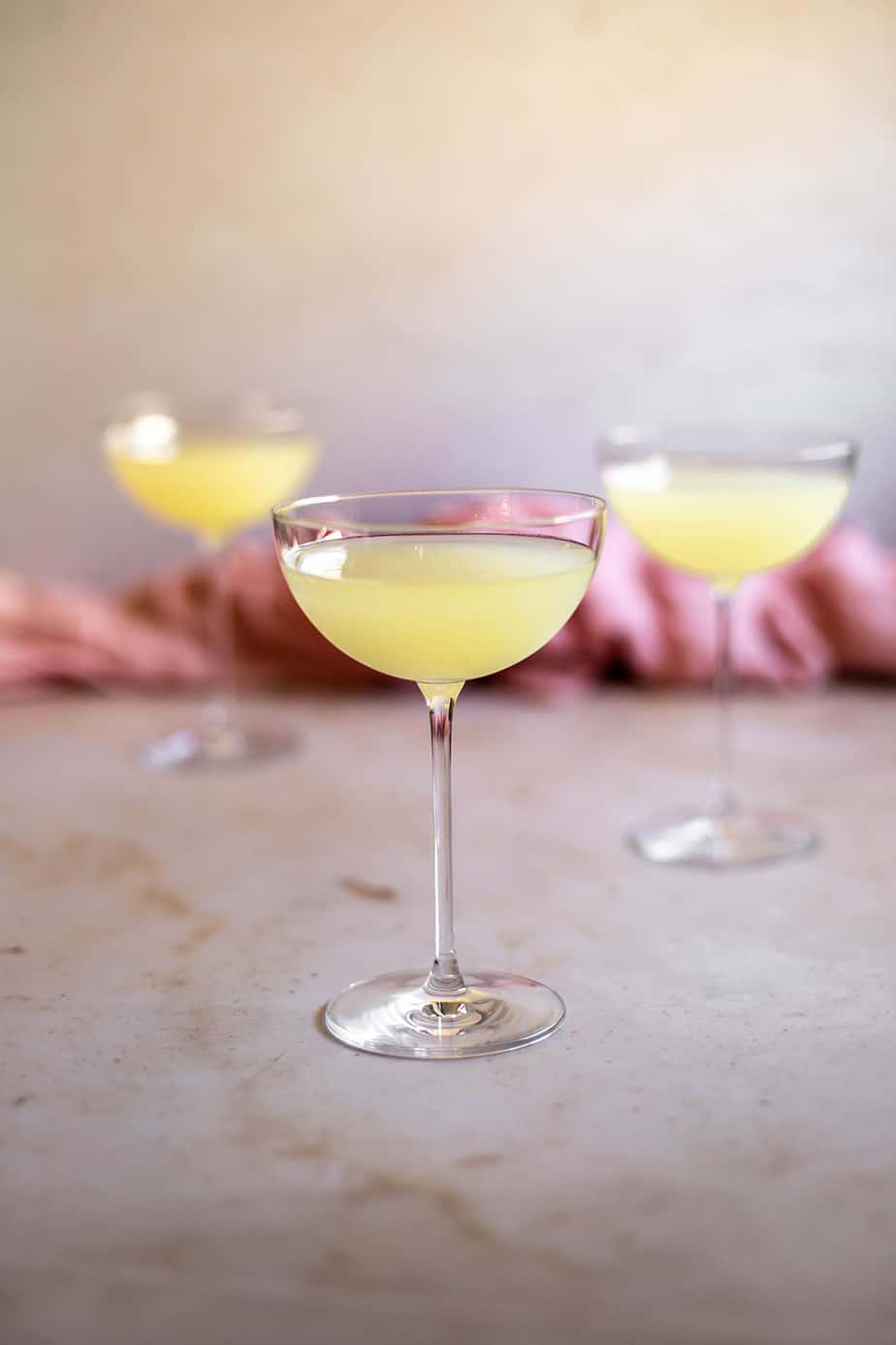 a straight on view of three coupe glasses filled with limoncello martinis