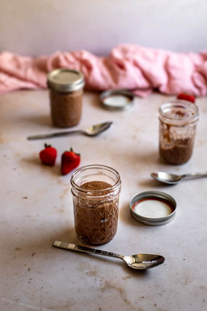 three 8 oz Mason jars filled with chocolate cheesecake