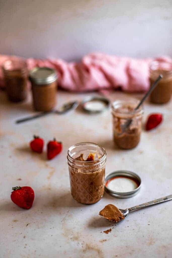 five 8 oz Mason jars filled with chocolate cheesecake