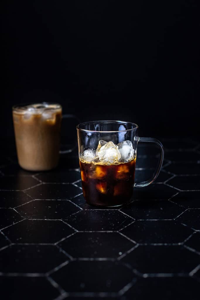 a clear glass mug filled with ice and espresso