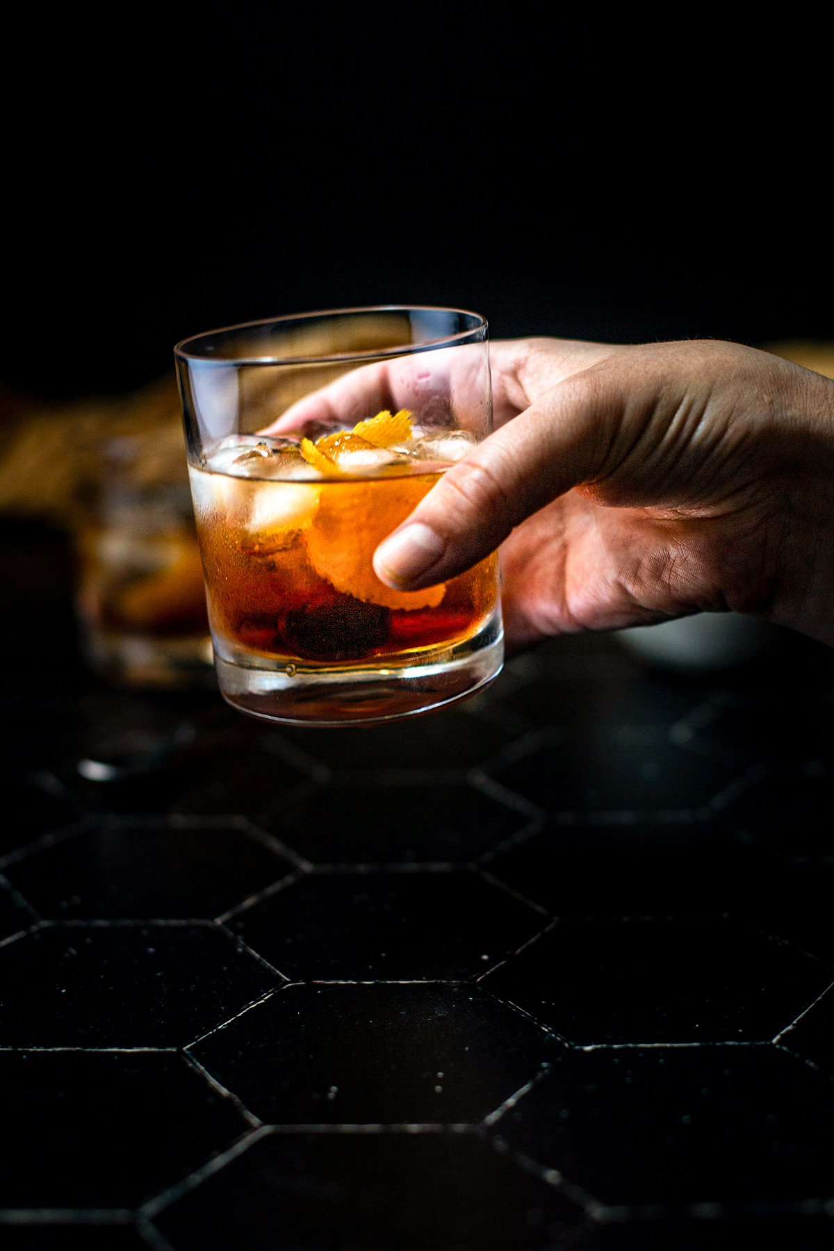 a hand holding a maple old fashioned
