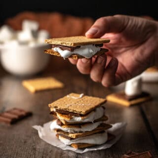 a stack of s'mores, with a hand holding one