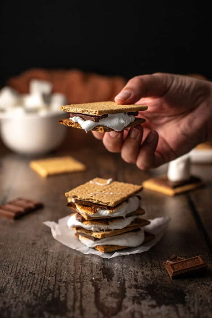 a stack of s'mores, with a hand holding one