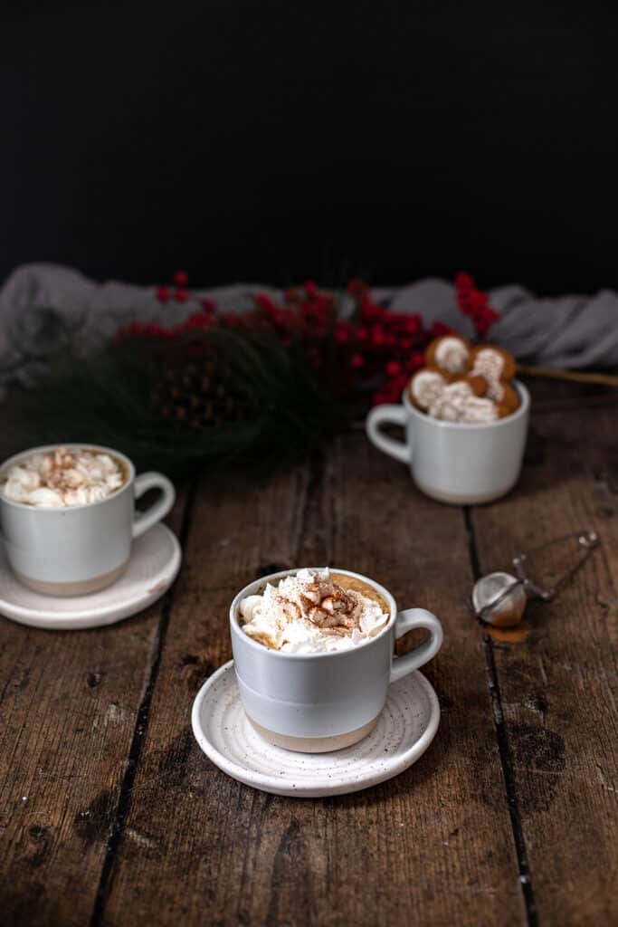 three mugs, two full of gingerbread lattes, the other full of gingerbread men