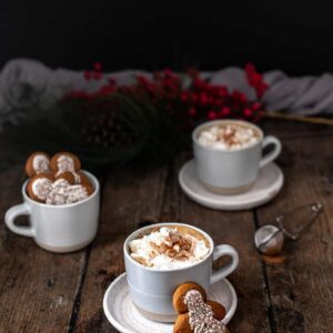 three mugs, two full of gingerbread lattes, the other full of gingerbread men