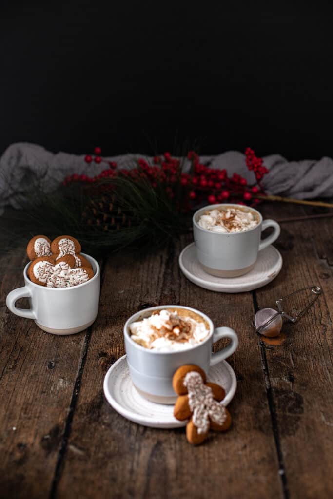 three mugs, two full of gingerbread lattes, the other full of gingerbread men