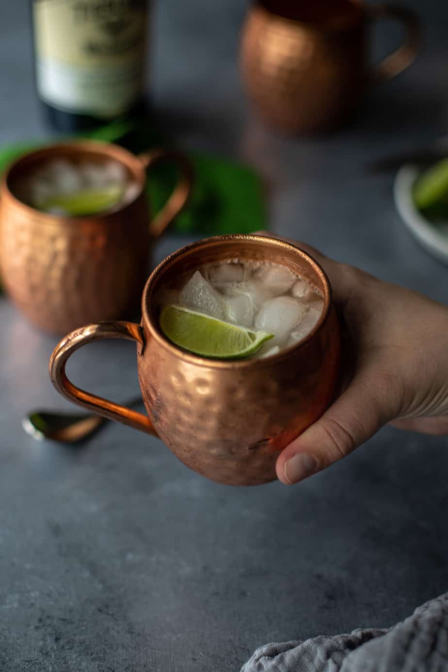 a hand holding an Irish Mule in a copper mug