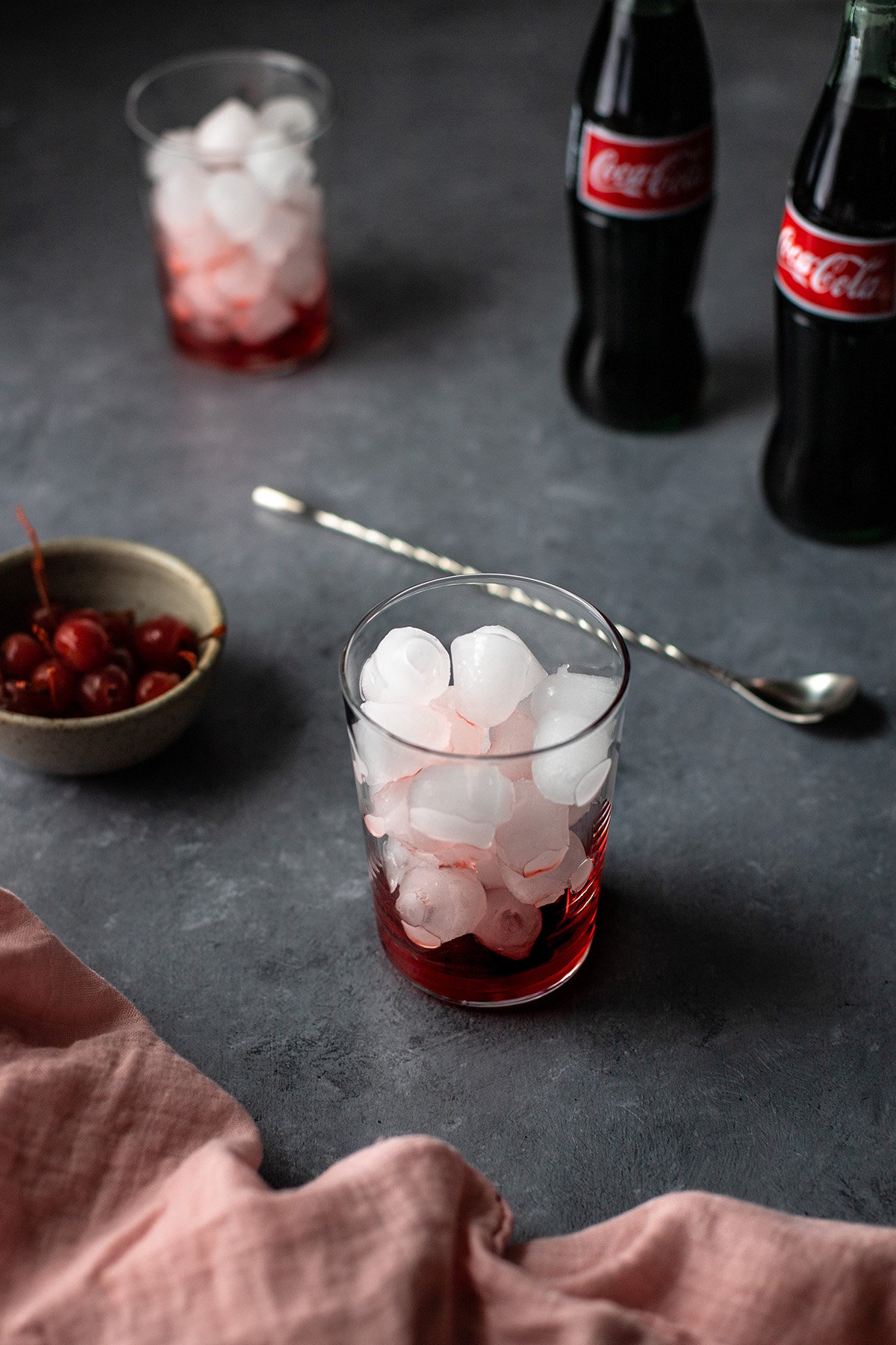 45 degree angle view of glass with ice and grenadine.