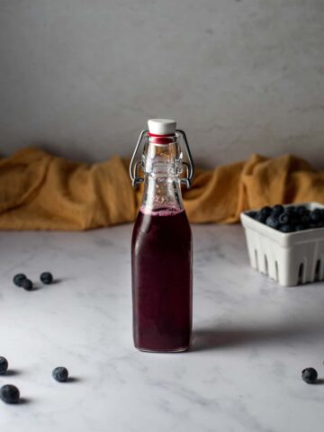 small swing top bottle full of blueberry simple syrup
