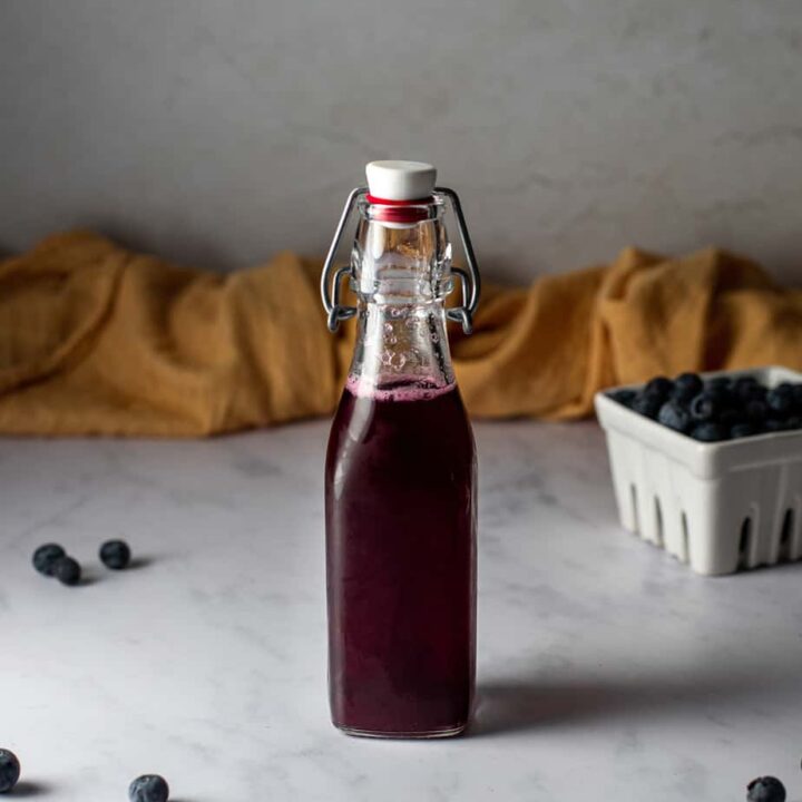 small swing top bottle full of blueberry simple syrup