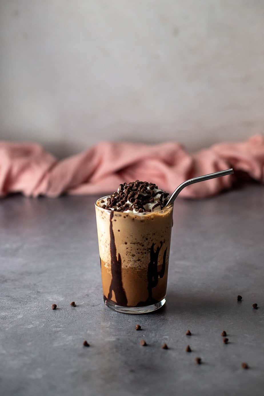 a java chip frappuccino in a glass with a metal straw