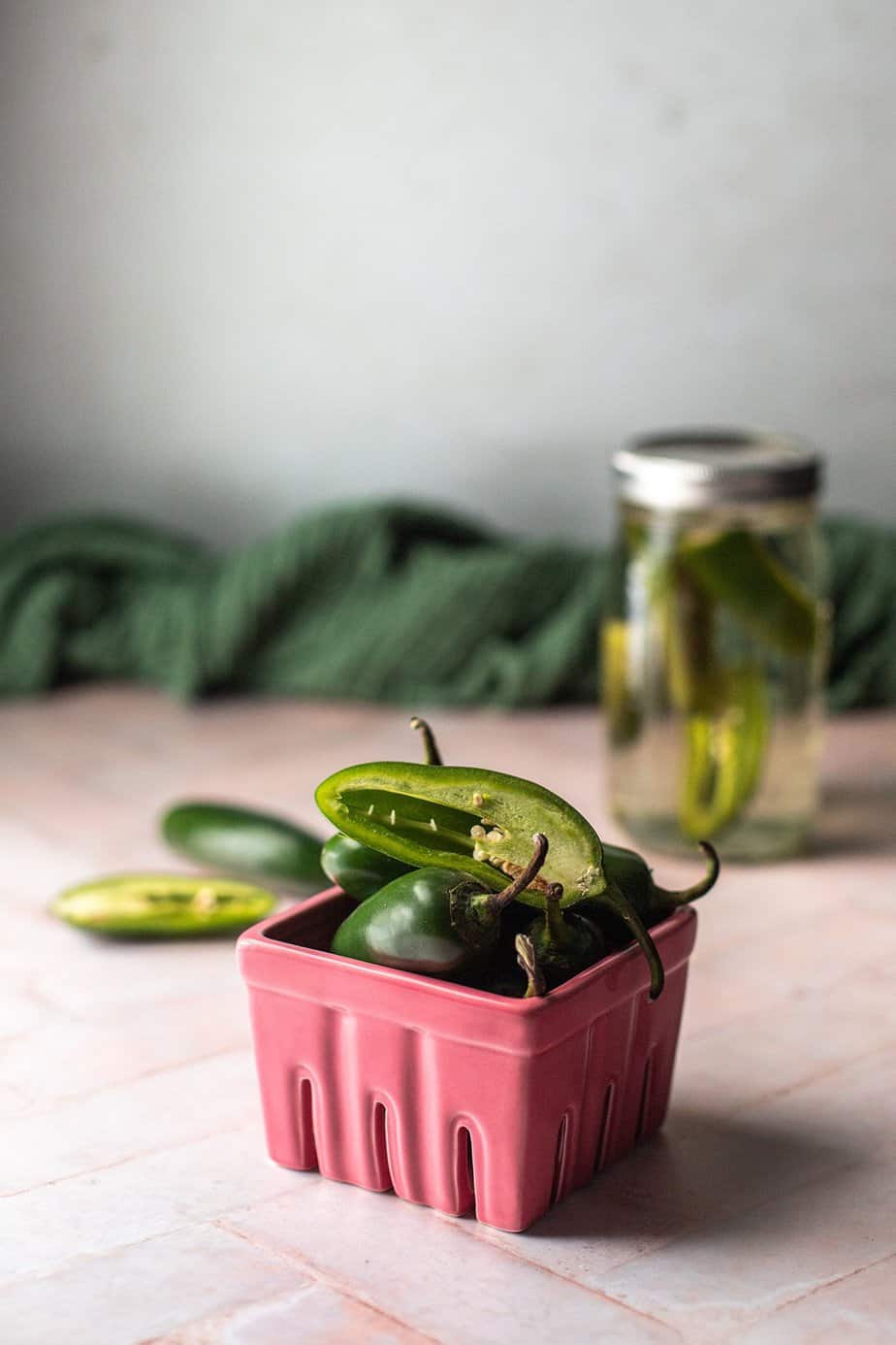 a small pink basket filled with jalpeños