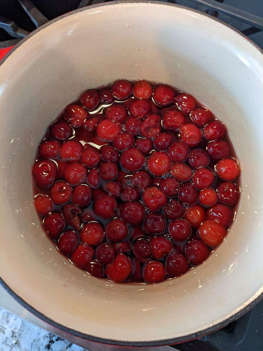 cherries in a saucepan of simple syrup