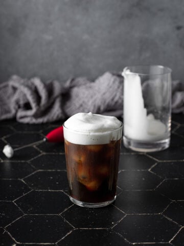 a glass of cold brew coffee topped with cold foam