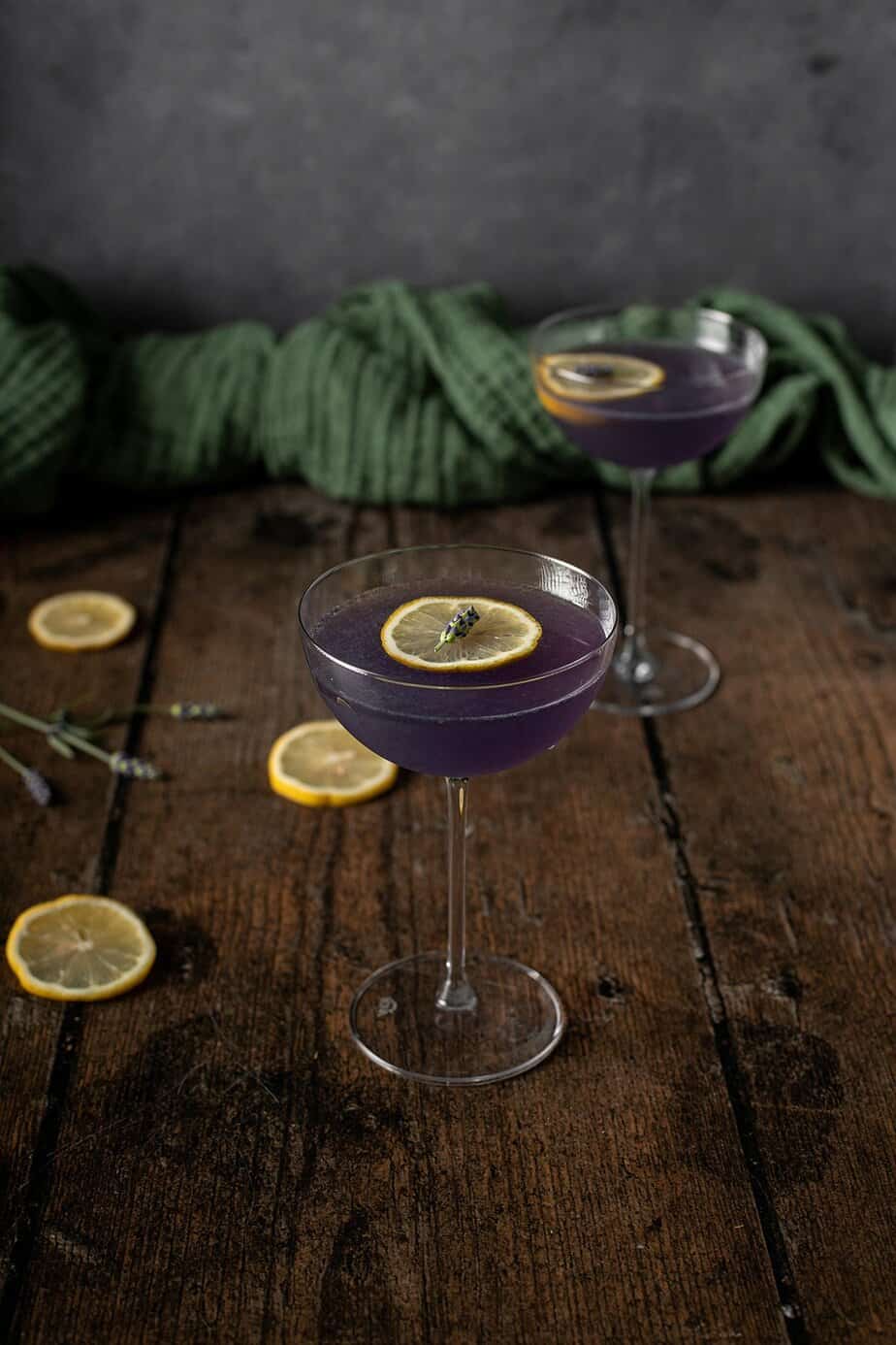 a nearly head on view of 2 coupe glasses full of lavender martinis