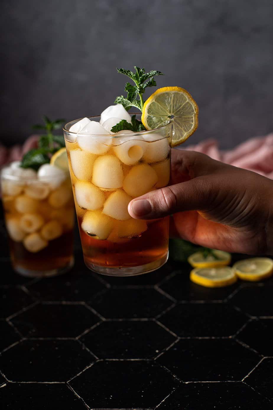 a hand holding a glass of cold brew iced tea