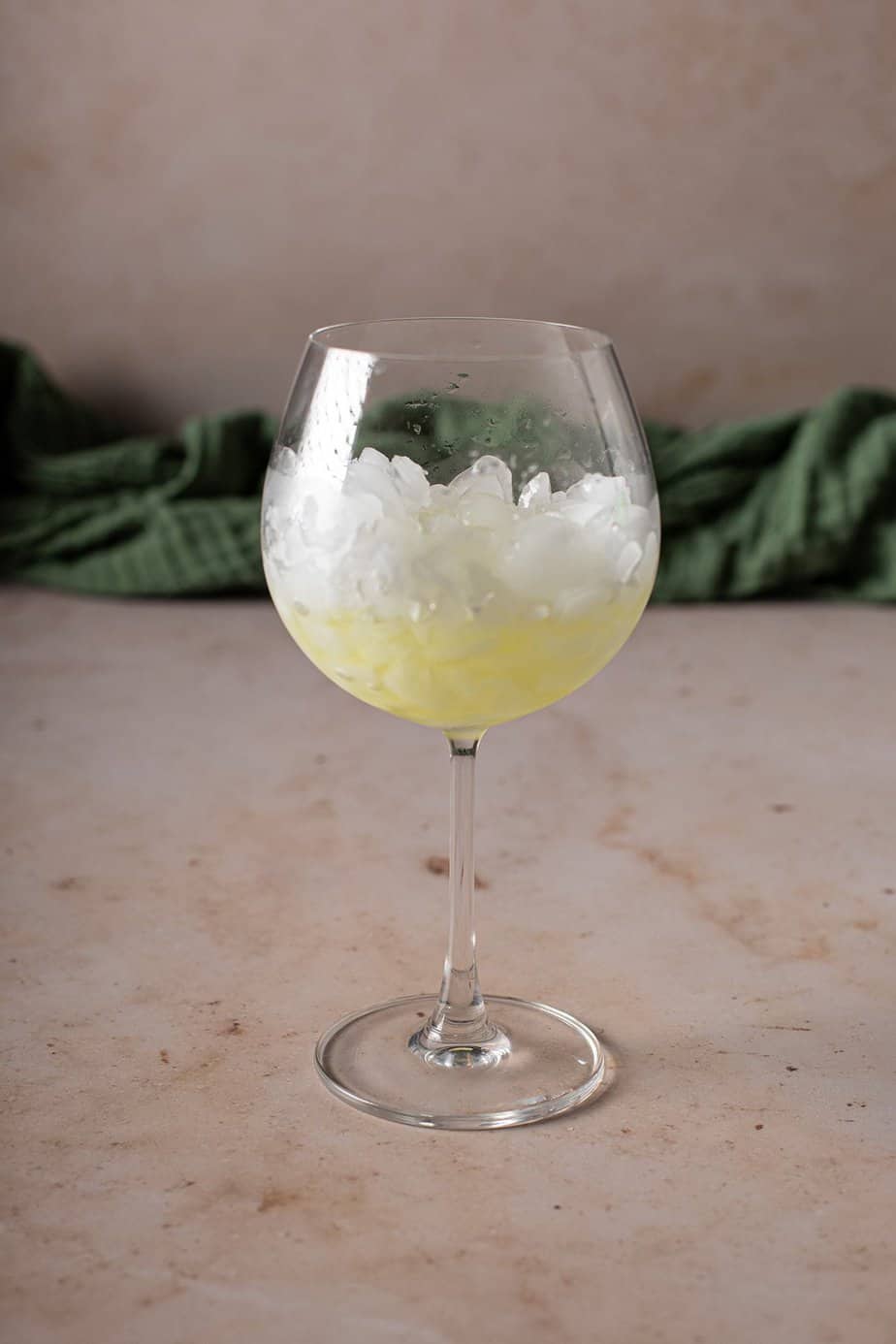 large wine glass filled with crushed ice and some limoncello
