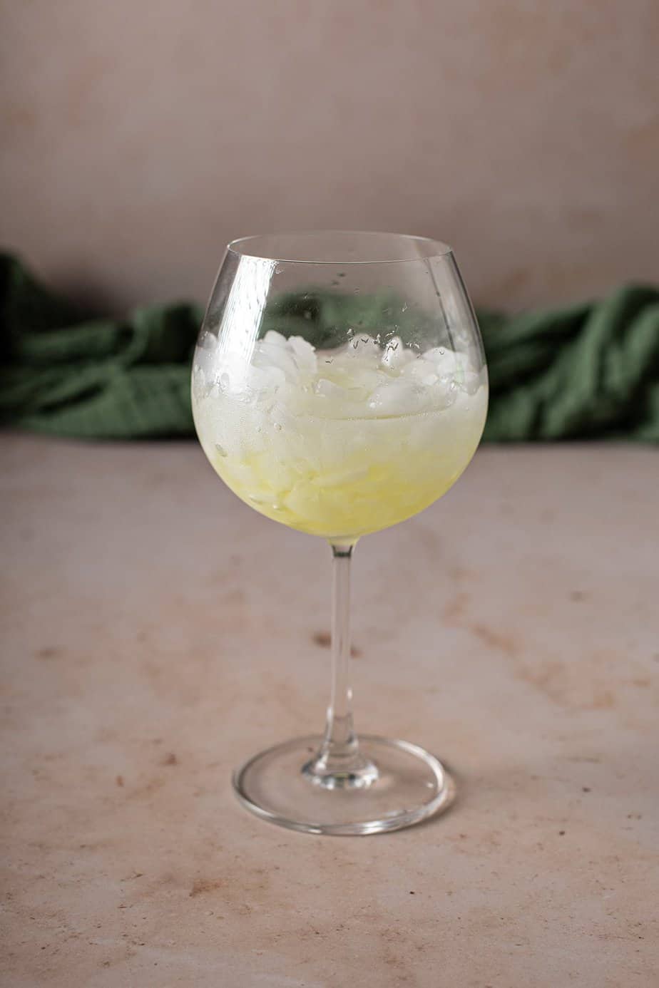 large wine glass filled with crushed ice and some limoncello and lemon juice