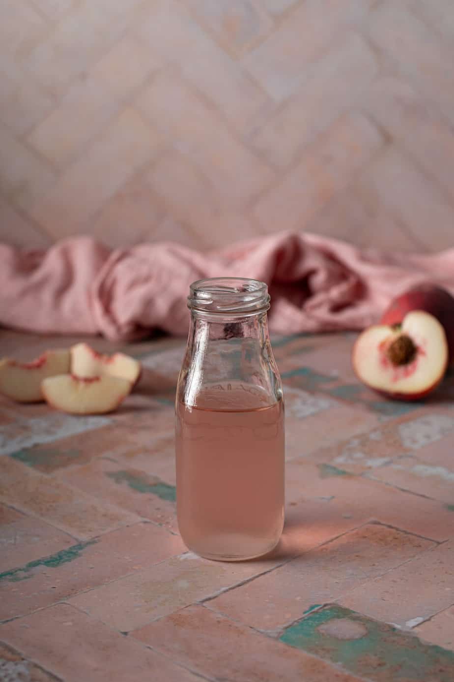 a small glass jar filled with peach simple syrup