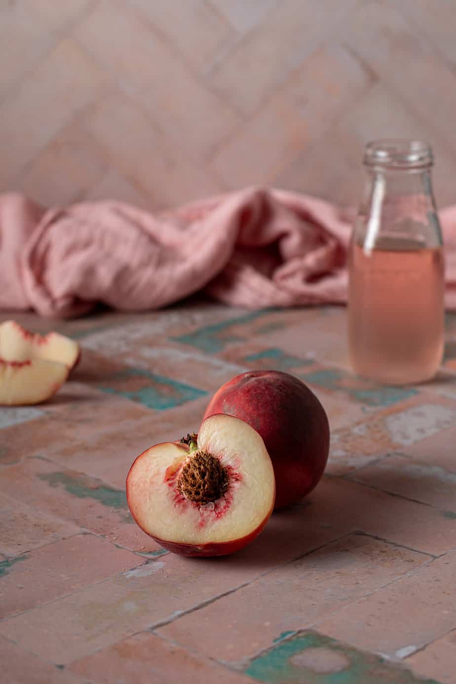 a peach and a peach half on a pink background