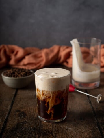 a glass of cold brew with pumpkin cream cold foam on top.