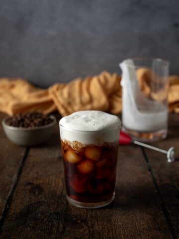 a glass of cold brew topped with salted caramel cream cold foam