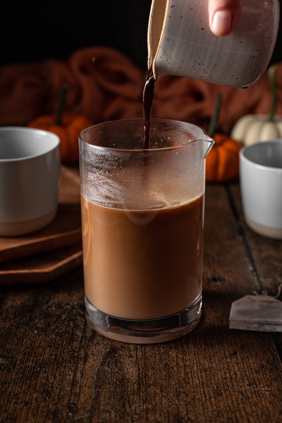 espresso being poured into a jar full of chai.