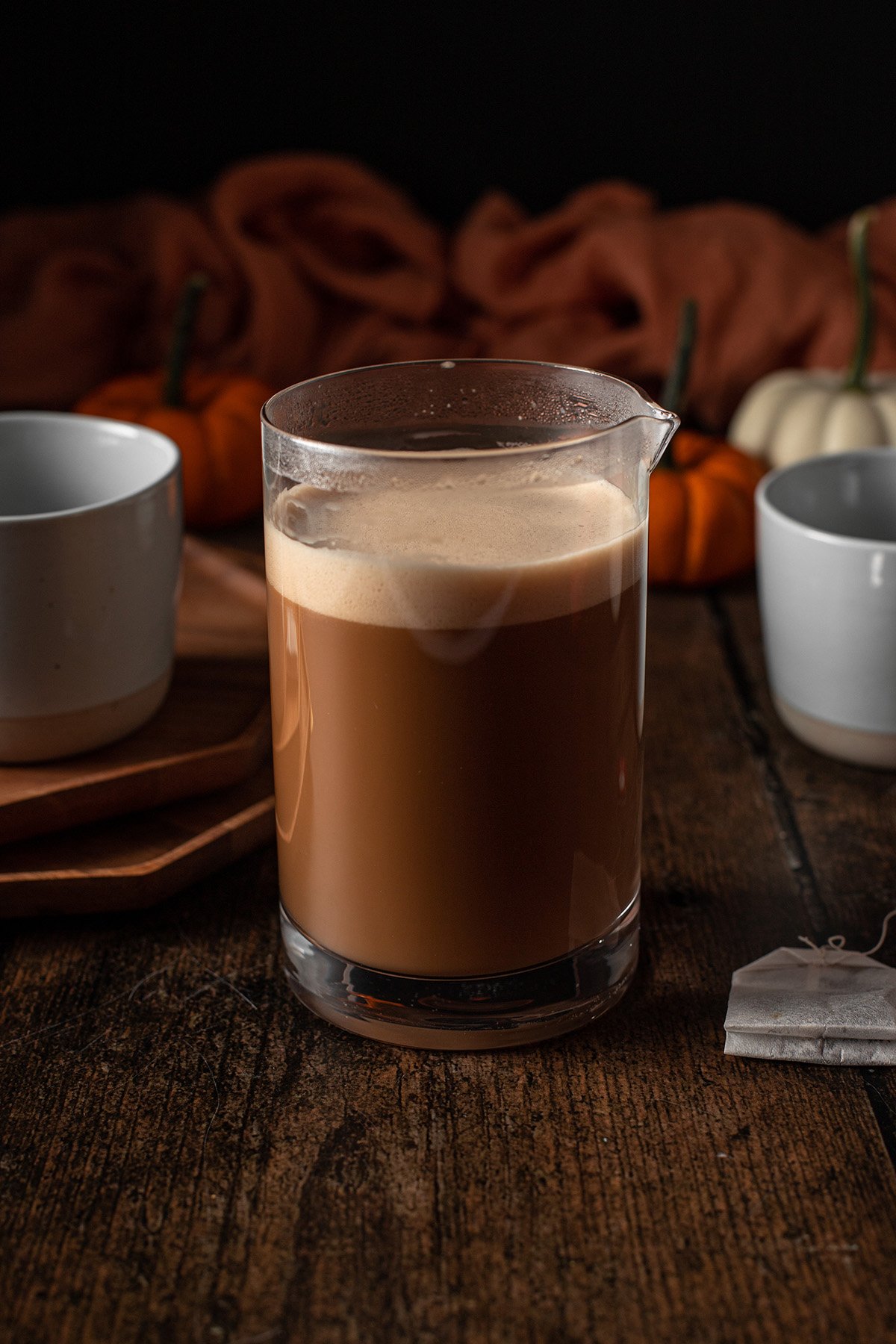 a jar full of chai that has been frothed; foam is on the top.