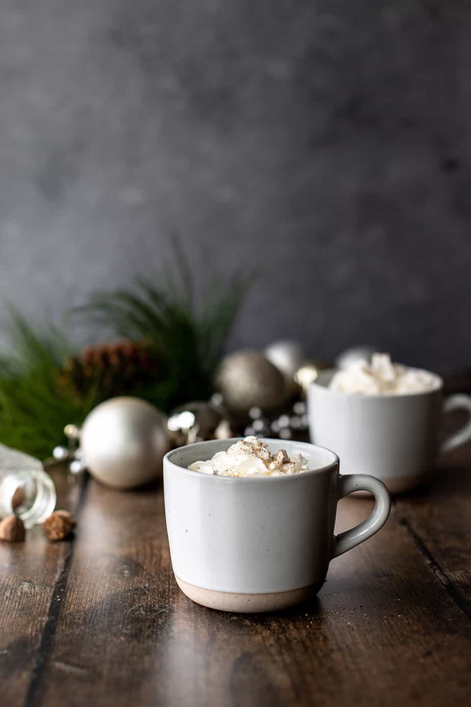 head on view of 2 mugs of eggnog lattes