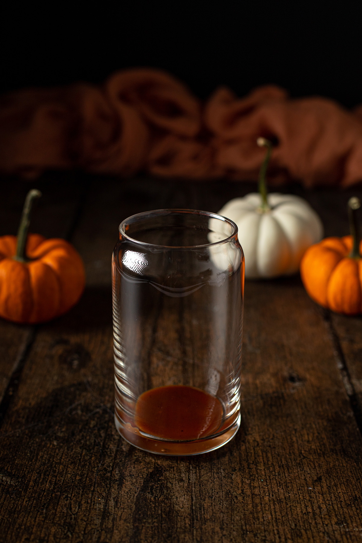 a glass with pumpkin spice syrup in the bottom