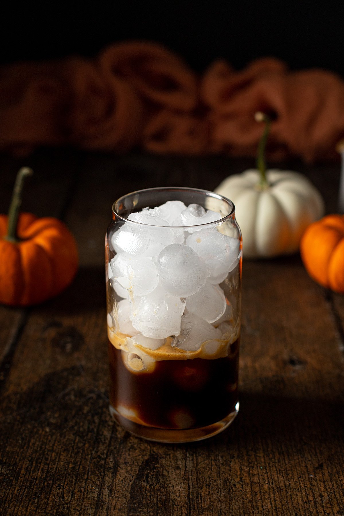 a glass with ice, espresso, and pumpkin spice syrup
