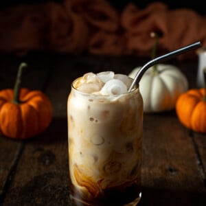 an iced pumpkin spice latte with a metal straw