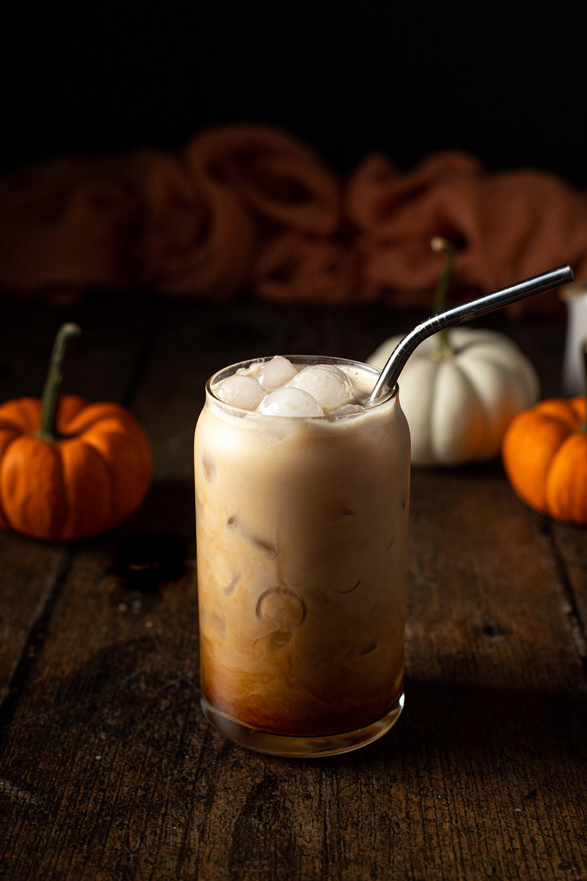 an iced pumpkin spice latte with a metal straw