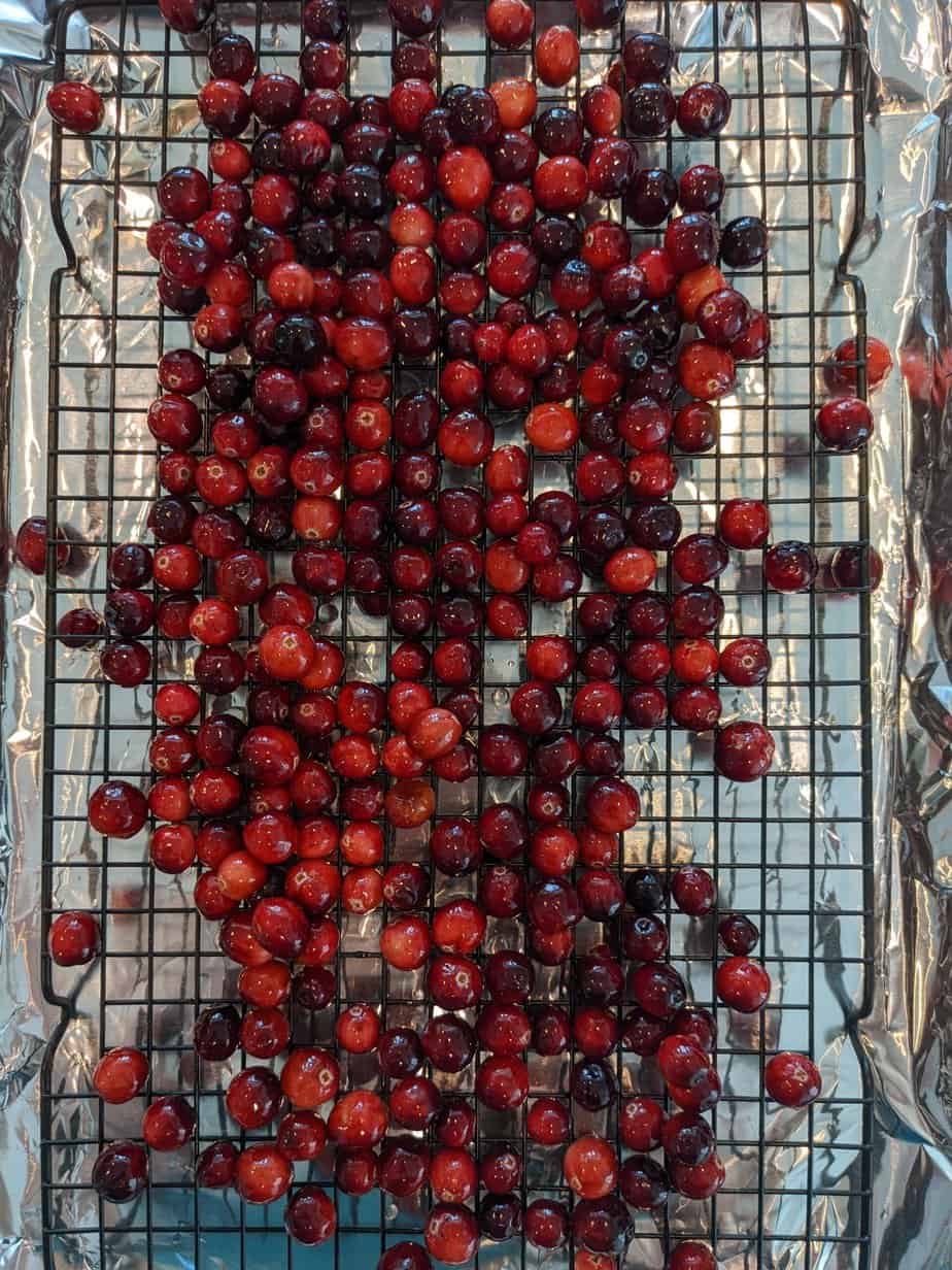 cranberries on a baking rack and a baking sheet
